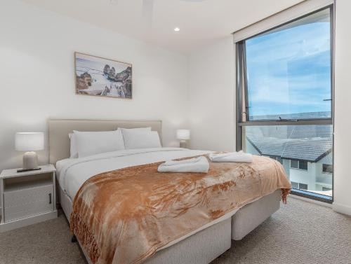 a bedroom with a large bed and a large window at Hemingway Palm Beach - Premium Oceanview Apartments in Gold Coast