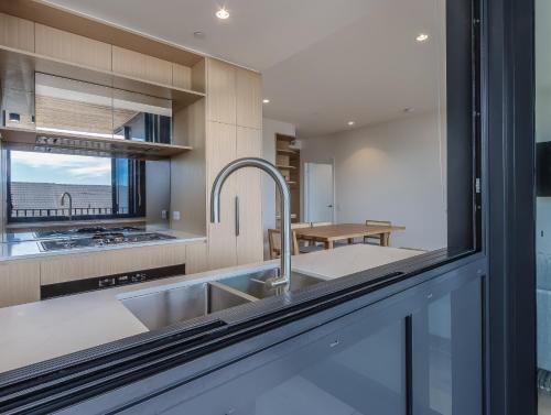 a kitchen with a sink and a counter at Hemingway Palm Beach - Premium Oceanview Apartments in Gold Coast