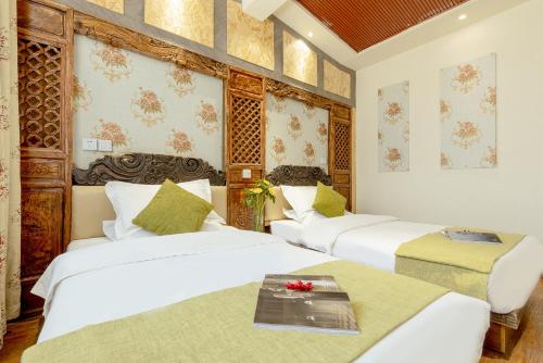 a hotel room with three beds and a table at RUI XIANG HE INN - Lijiang Ancient Town in Lijiang