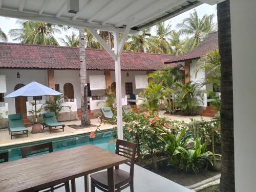 a view of the courtyard of a house with a table and chairs at White Coconut Resort in Gili Trawangan