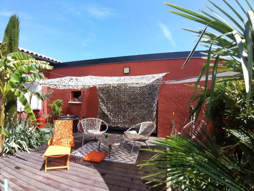 une terrasse avec des chaises et un filet dans un bâtiment dans l'établissement Studio rouge Lagon, à Romans-sur-Isère