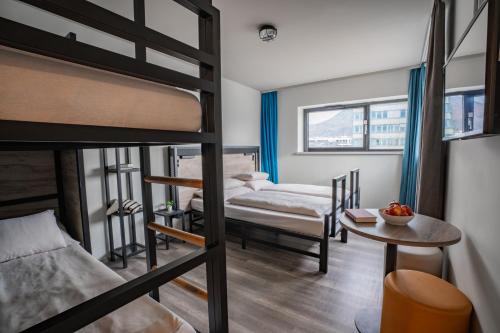 Zimmer mit 2 Etagenbetten und einem Tisch in der Unterkunft harry's XL Hotel in Salzburg