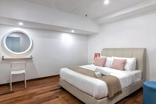 a bedroom with a large bed and a mirror at Sunrise @ Gurney in George Town