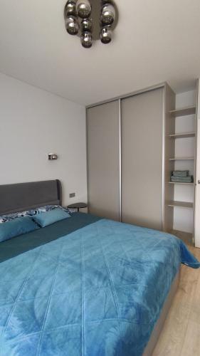 a bedroom with a large bed with a blue blanket at NEW J&R Apartment near Girstutis, Free private parking & Self Check-In in Kaunas