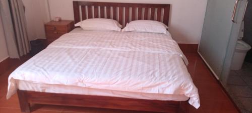 a bed with white sheets and pillows in a bedroom at 阳光客栈 in Luang Prabang