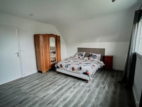 um quarto com uma cama e piso em madeira em KAZE Maison chaleureuse Evreux, quartier résidentiel Saint Michel em Évreux