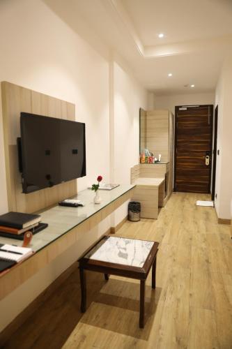 a living room with a flat screen tv on a wall at HOTEL LE SEASONS PARK in Greater Noida