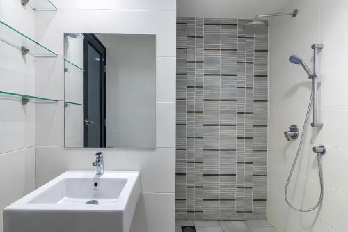 a bathroom with a sink and a shower at Sunrise @ Gurney in George Town