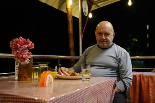 um homem sentado à mesa com um prato de comida em Sea Pearl Homestay em Port Blair