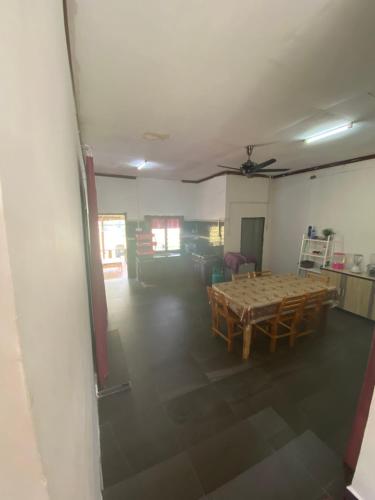 een woonkamer met een tafel en een kamer met een plafond bij Chu Mon's Homestay Janda Baik (15 min from river) in Bentong