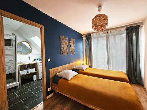 a bedroom with two beds and a mirror at Cozy Nest Paris 25mn Disney 20mn in Meaux