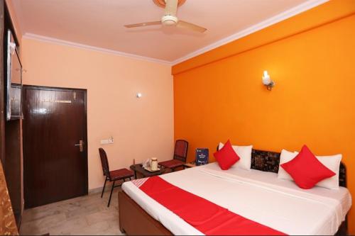 sypialnia z dużym łóżkiem z czerwonymi poduszkami w obiekcie Hotel The New Avenue w mieście Aligarh
