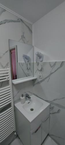 bagno bianco con lavandino e specchio di Antic house a Predeal