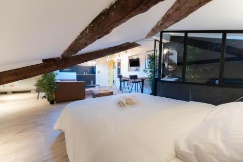 une chambre avec un grand lit blanc et un salon dans l'établissement Superbe Loft - Vieux Nice - Balnéo, à Nice