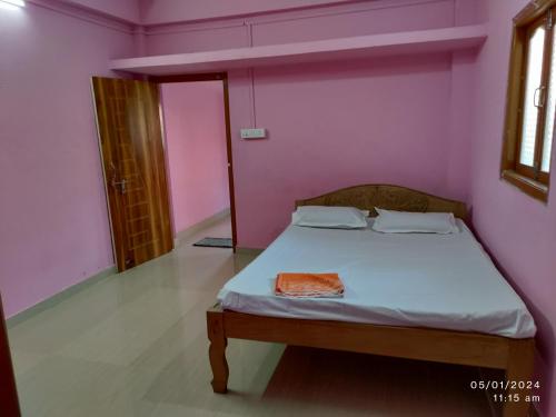 a bedroom with a bed in a pink room at Harmony Waves Homestay in Havelock Island
