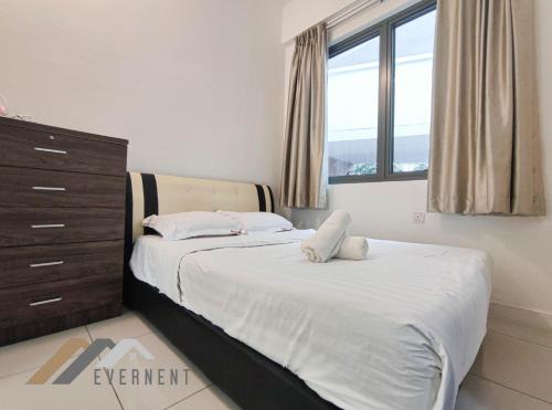 two beds in a bedroom with a dresser and window at Marina Times Square Homestay by Evernent in Miri