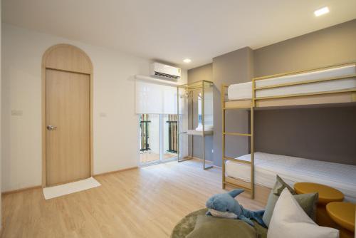a bedroom with bunk beds and a stuffed animal on a couch at Diya Hotel Bangkok in Amphoe Phra Khanong