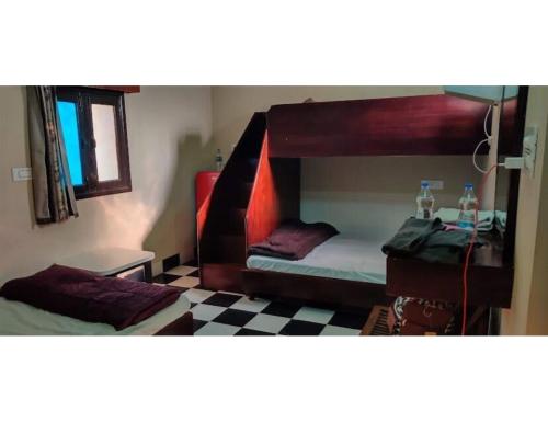 1 dormitorio con 2 literas y suelo a cuadros en Virasat Haweli, Mannavala, Punjab, en Jandiāla Guru