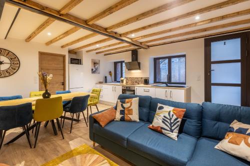 Una sala de estar con un sofá azul y una mesa. en Le Cocon Enneigé - Duplex 3 chambres, en Formiguères