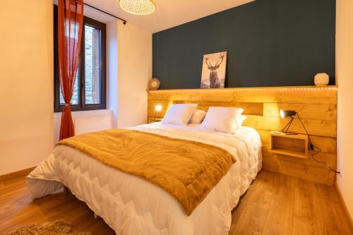 1 dormitorio con 1 cama grande y cabecero de madera en Le Cocon Enneigé - Duplex 3 chambres, en Formiguères