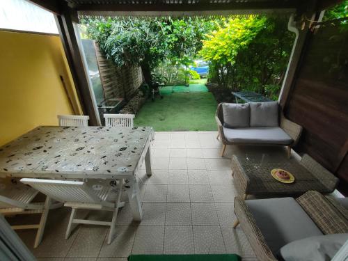 a screened in porch with a table and chairs at Petite maison à 12mn du bassin de Manapany in Saint-Joseph