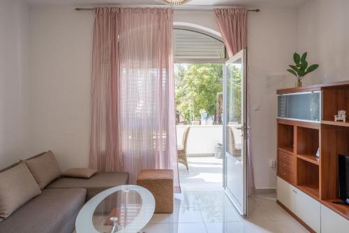 ein Wohnzimmer mit einem Sofa und einem Glastisch in der Unterkunft Apartments K & N in Prizba