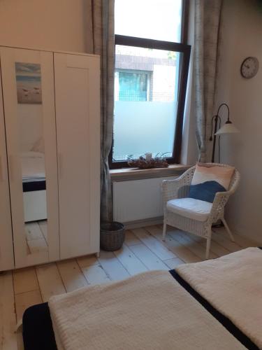 - une chambre avec une fenêtre, une chaise et un lit dans l'établissement Ferienwohnung "Kleine Möwe", à Bremerhaven
