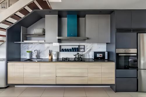 a kitchen with white and black cabinets and appliances at Sunrise @ Gurney in George Town
