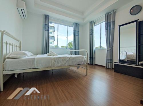 a bedroom with a bed and some windows at Serene Heights by Evernent in Miri