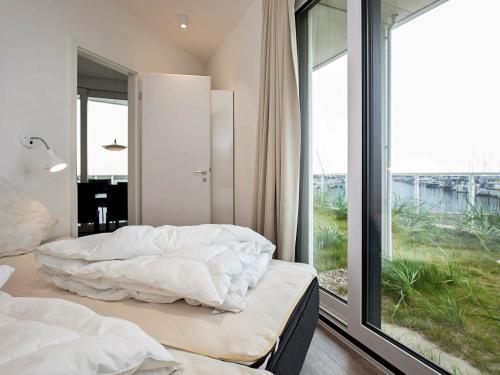 a bedroom with two beds and a large window at Two-Bedroom Holiday home in Wendtorf 29 in Wendtorf