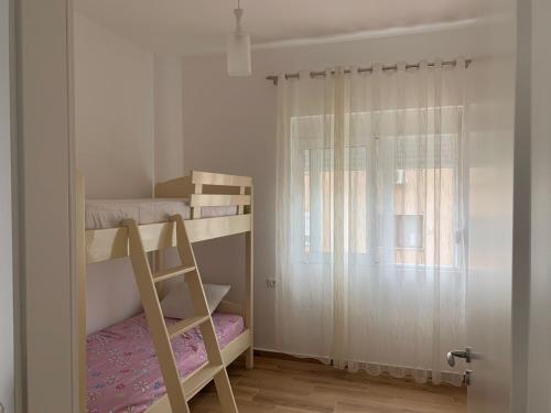 een slaapkamer met twee stapelbedden en een ladder bij Properhome Saranda in Sarandë