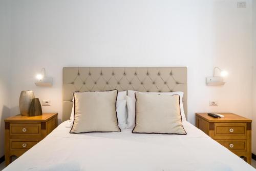 a bedroom with a white bed with two night stands at Al Duomo Rooms & Flats in Taormina