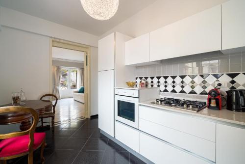 a kitchen with white cabinets and a table at Al Duomo Rooms & Flats in Taormina