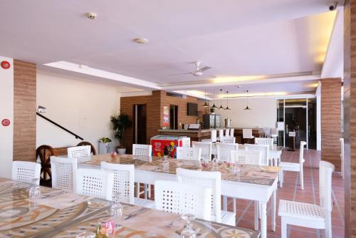 a large dining room with white tables and white chairs at Sierra Hotel in Dumaguete