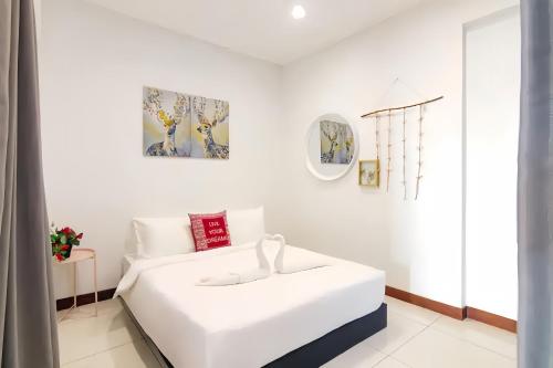 a white bedroom with a white bed in a room at Sunrise @ Gurney in George Town