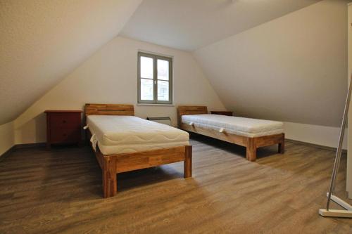 1 dormitorio en el ático con 2 camas y ventana en Holiday flat am Krakower See Krakow am See - DMS02203-P, en Krakow am See