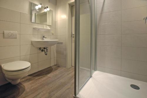 y baño con aseo, lavabo y ducha. en Holiday flat am Krakower See Krakow am See - DMS02203-P, en Krakow am See