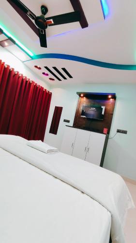 a room with two beds and a flat screen tv at Hotel Dwarika in Chandrapur