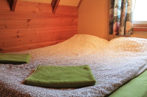 a bed with two green towels on top of it at Hömluholt Holiday Homes in Hömluholt