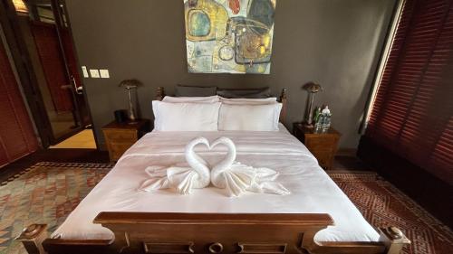 a bed with two white bows on it at Private Beach House @ Hin Kong Beach in Hinkong