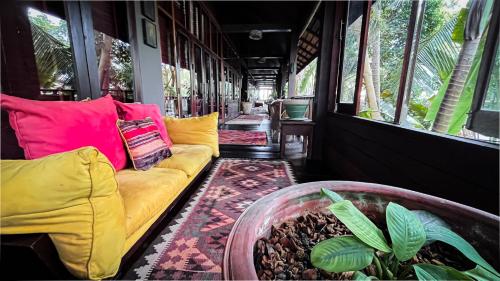 a train car with a yellow couch and a plant at Private Beach House @ Hin Kong Beach in Hinkong