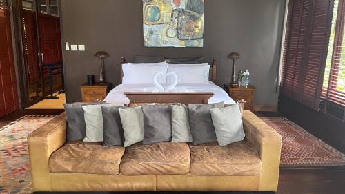 a bed with a couch with pillows on it at Private Beach House @ Hin Kong Beach in Hinkong
