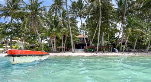 a boat in the water in front of a beach at Private Beach House @ Hin Kong Beach in Hinkong