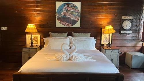 a bed with two heart shaped towels on it at Private Beach House @ Hin Kong Beach in Hinkong