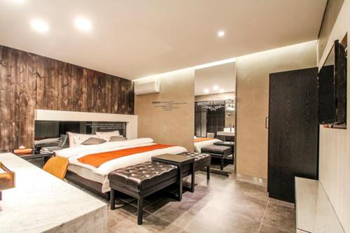 een slaapkamer met een bed, een bureau en een televisie bij Jamsil 2.4 Hotel in Seoul