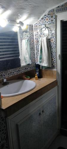a bathroom with a sink and a counter with a mirror at L'Oa in Rabat