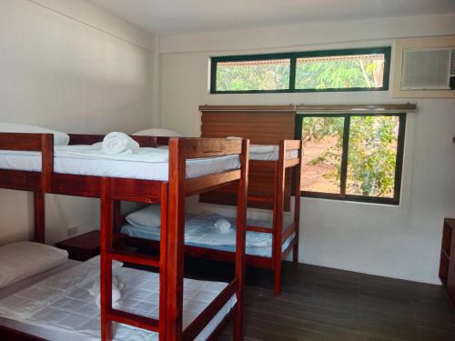 a room with three bunk beds and a window at Villa Marilyn Resort and Hotel in Coron