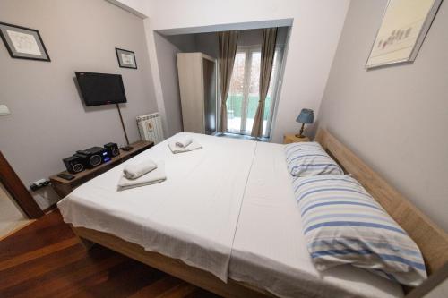 a large bed in a room with a window at Lux Place Apartments Downtown in Kragujevac