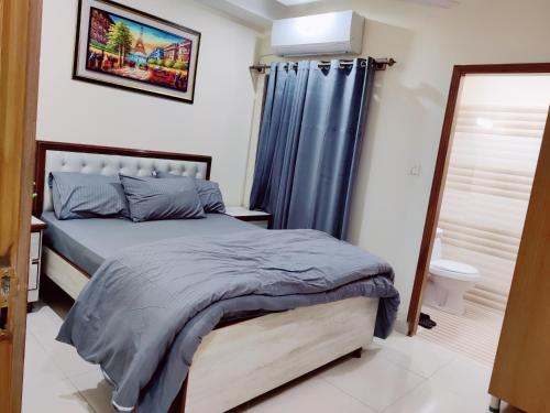 a bedroom with a bed and a shower at SR Apartments Islamabad in Islamabad