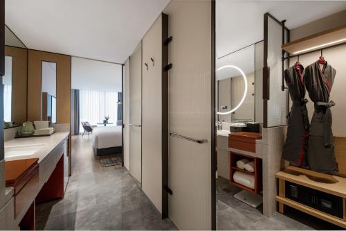 a bathroom with a sink and a room with a bed at IntercityHotel Shanghai New International Expo Center in Shanghai